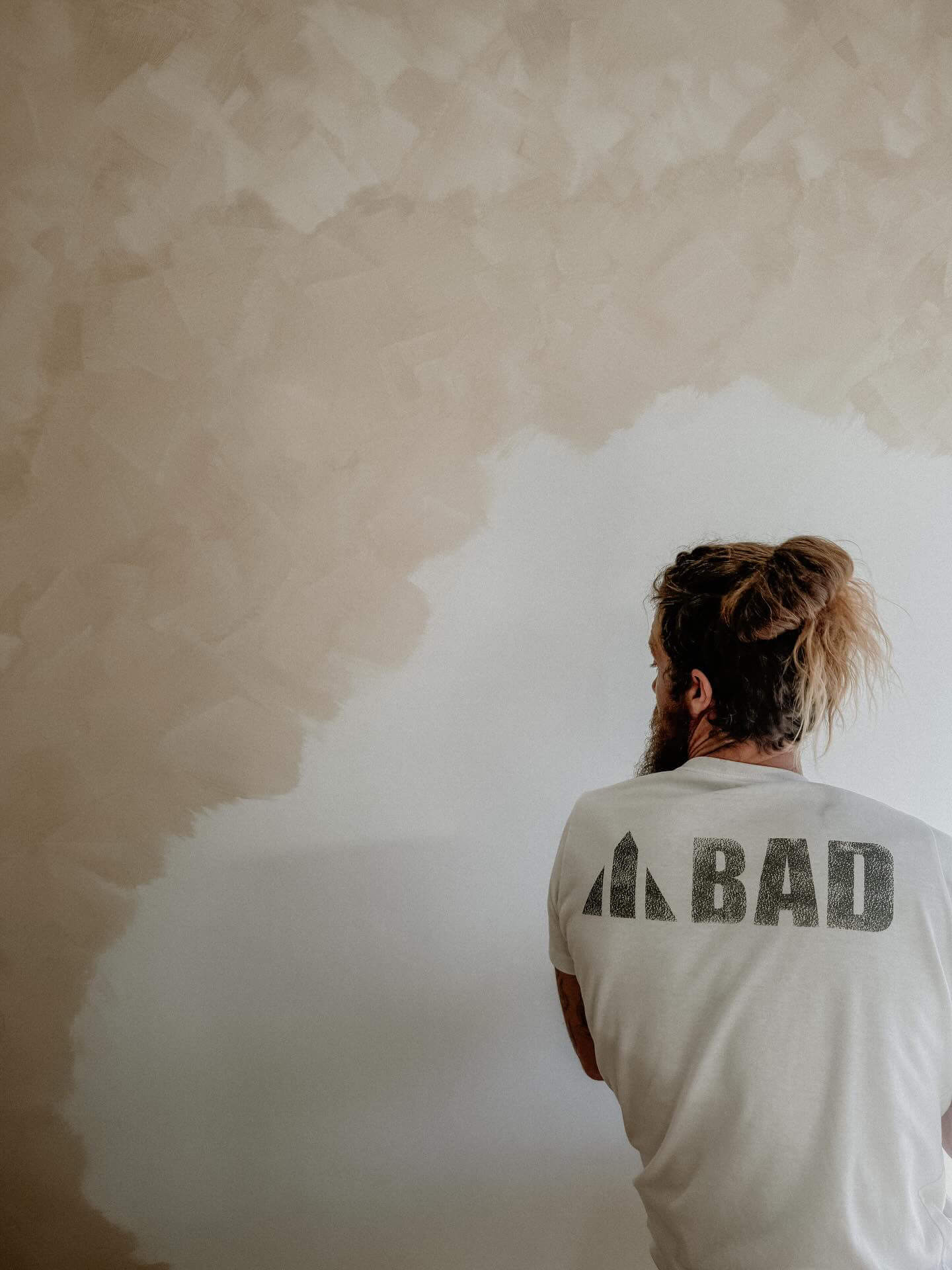 Person painting with limewash paint and block brush