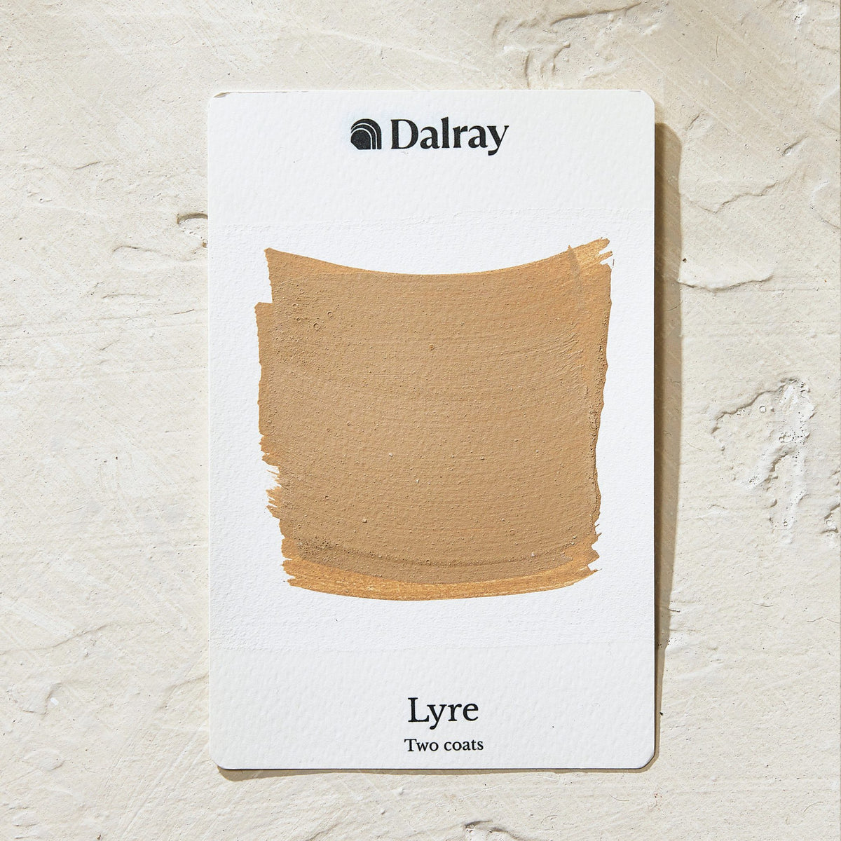 A Dalray limewash texture color card showing the shade 'Lyre' with two coats applied, displayed on a textured beige background.
