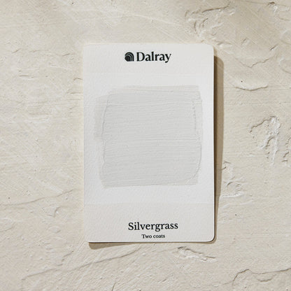 A Dalray paint swatch card labeled 'Silvergrass', a light greige with green undertones, with two coats applied, placed on a textured off-white surface.