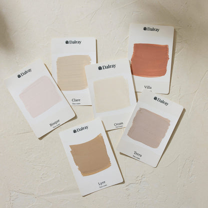 Six Dalray paint A6 limewash swatch cards arranged on a textured cream surface, showing different neutral and warm shades including Blush, Clare, Cream, Terra, and Lyre.